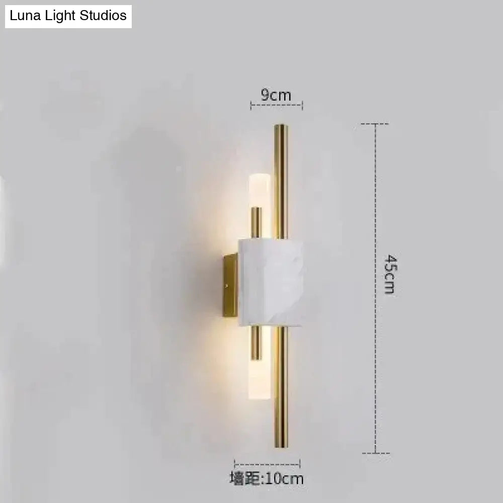 Modern brass and green marble led wall lamp featuring a white marble led wall block with gold rods emitting warm light