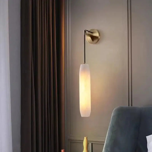 Modern brass and marble wall lamp with a warm-toned cylindrical frosted glass shade and brass-finished mounting bracket decorbites cylindrical