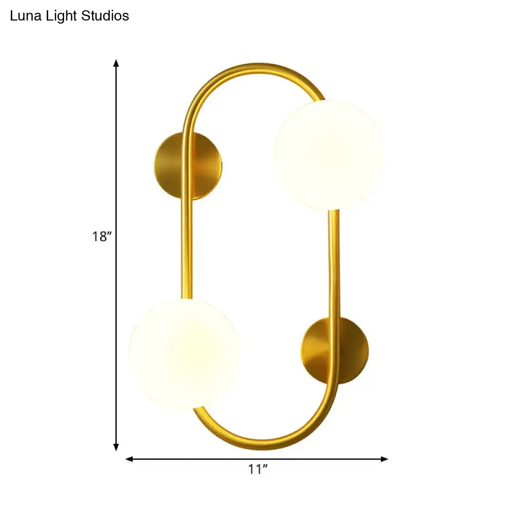 Modern brass and milk glass led wall mount lamp with gold-toned curved frame and two frosted glass globe shades