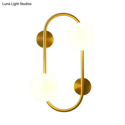 Modern brass and milk glass led wall mount lamp with gold-toned fixture and two frosted glass globes for bedroom use