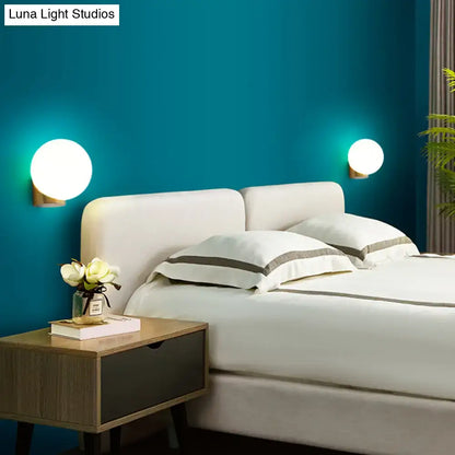 Modern brass and opal glass wall mount lamp with round glowing white sconces for bedside bedroom use