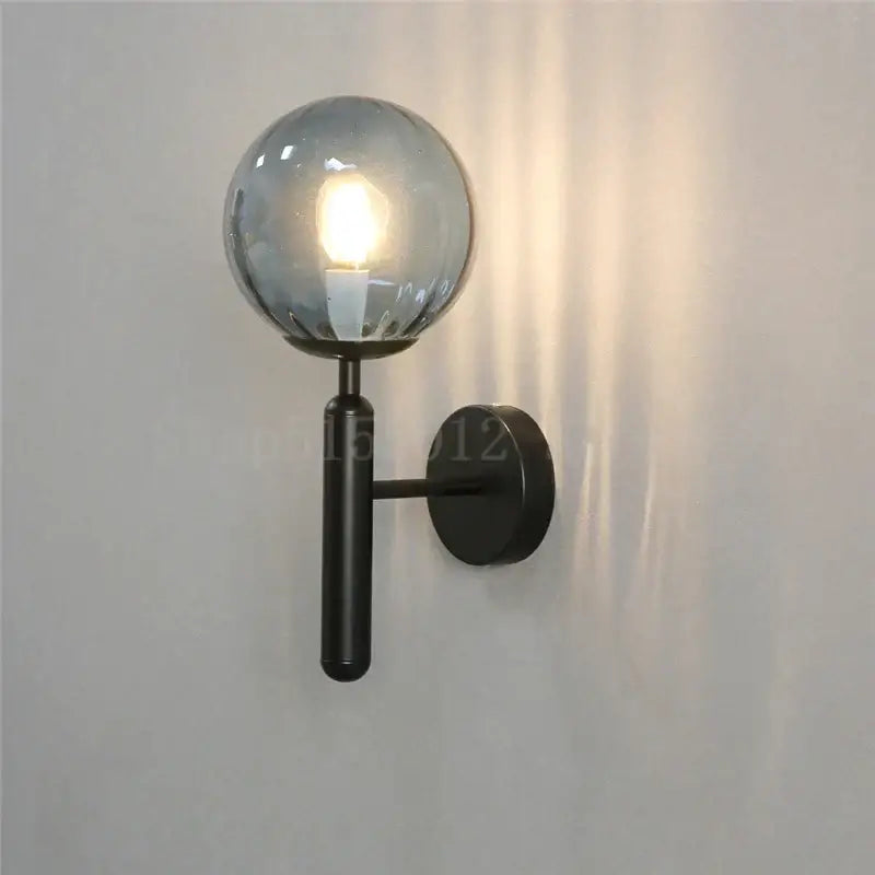 Black metal wall sconce with frosted glass globe complementing modern brass and pink glass wall sconce decorbites blue glass balls