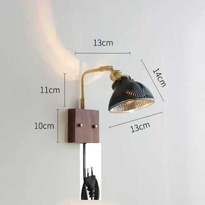 A vintage-style wall light with brass arm and dark green ribbed glass shade on wooden base décorbites clear glass design