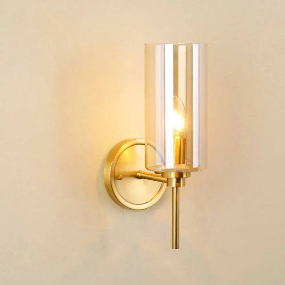Modern brass and smoked glass wall sconce with gold-toned finish and cylindrical shade featuring e26 bulb base