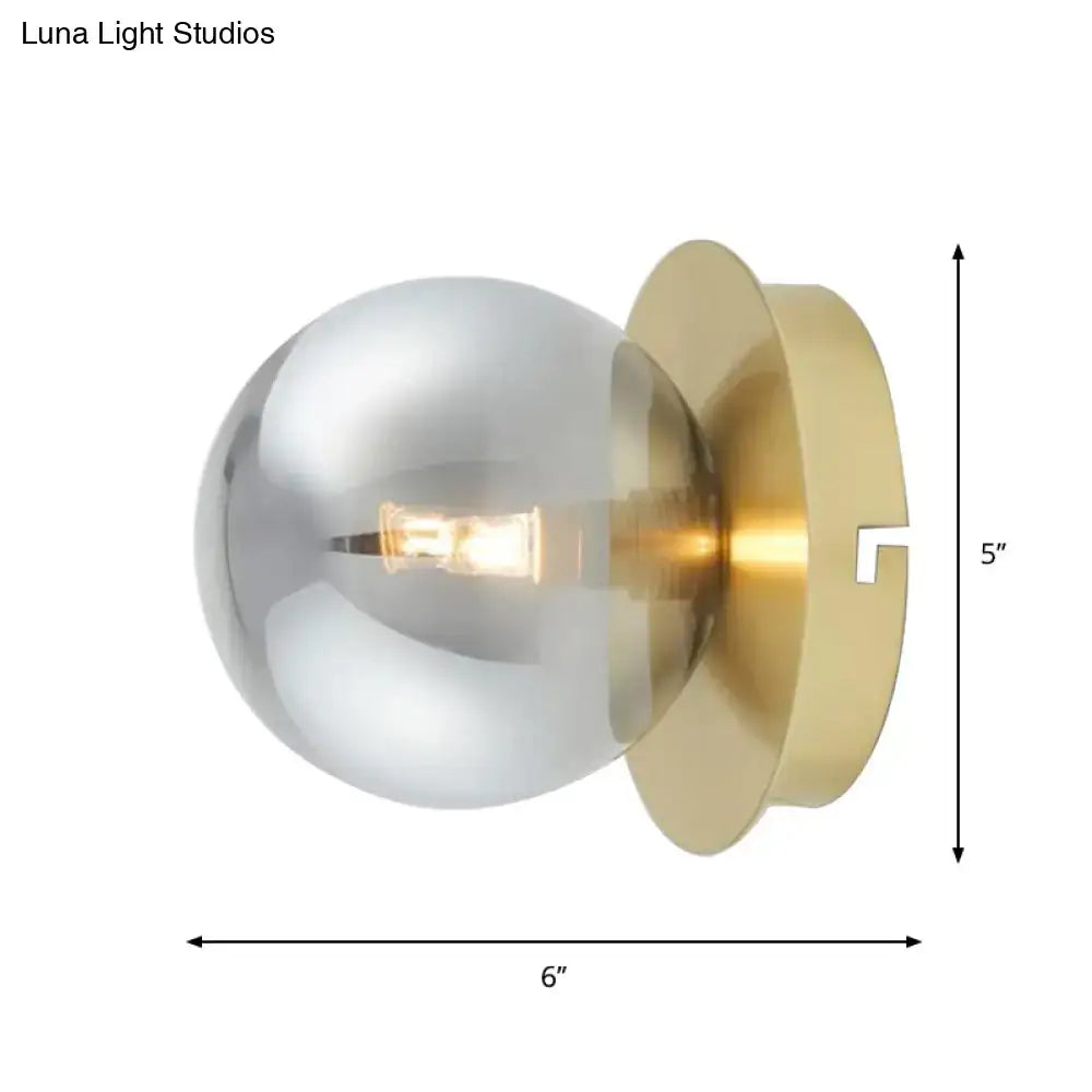 Modern brass wall lamp with smoky glass shade and exposed filament bulb as stylish bedroom light fixture
