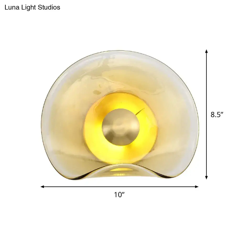 Modern brass and tan glass wall light fixture featuring a sleek amber glass lamp with warm yellow glow bulb wattage second gear
