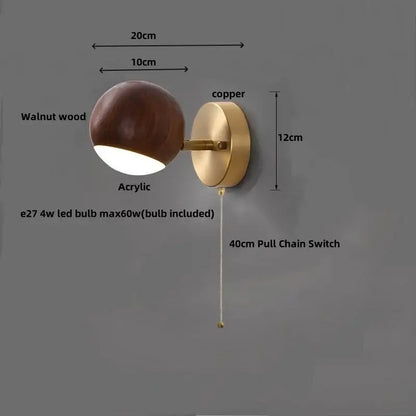 Modern brass and walnut led wall sconce with copper accents and a spherical acrylic diffuser for bedroom lighting