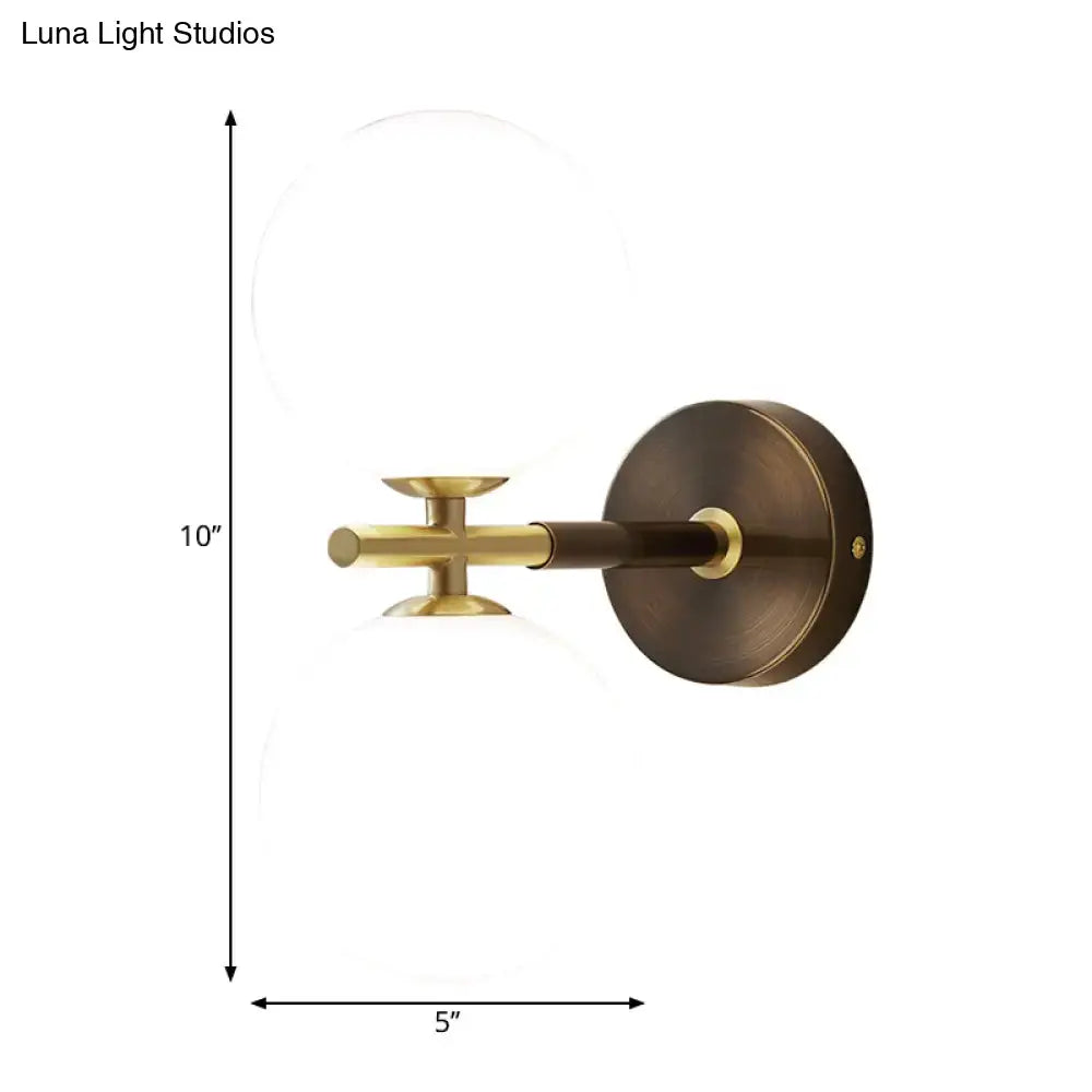 Modern brass and white glass wall sconce with a circular base and frosted globe for elegant bedroom lighting