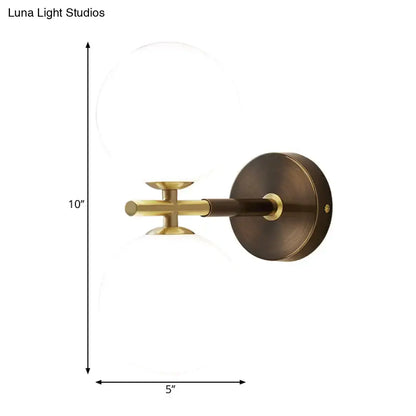 Modern brass and white glass wall sconce with a circular base and frosted globe for elegant bedroom lighting