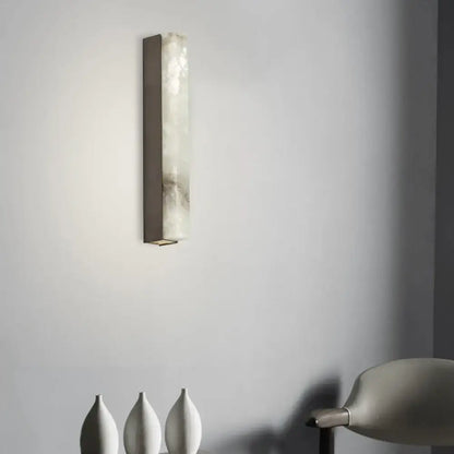 Modern brass and white onyx living room wall lighting featuring a rectangular sconce with translucent onyx panel and dark metal frame