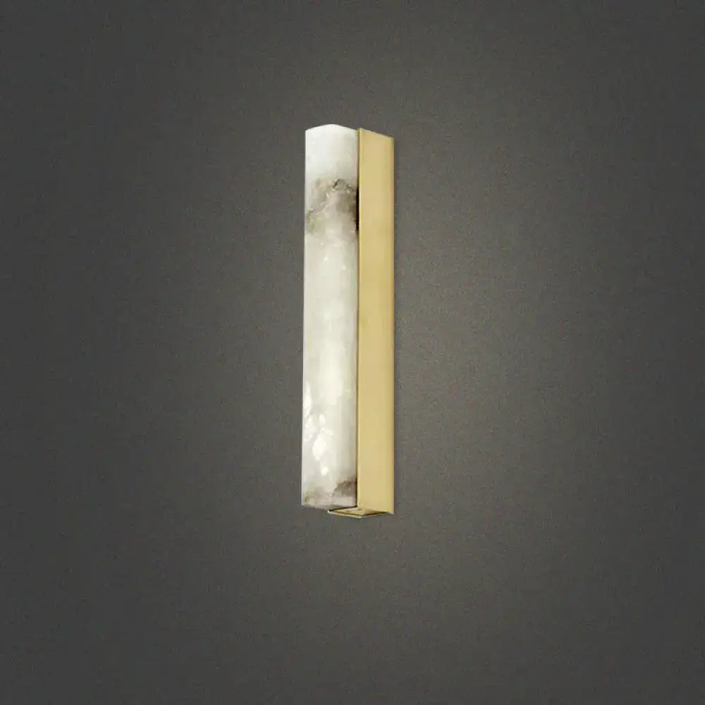 A modern brass and white onyx wall lighting sconce with translucent onyx and polished brass for living room use