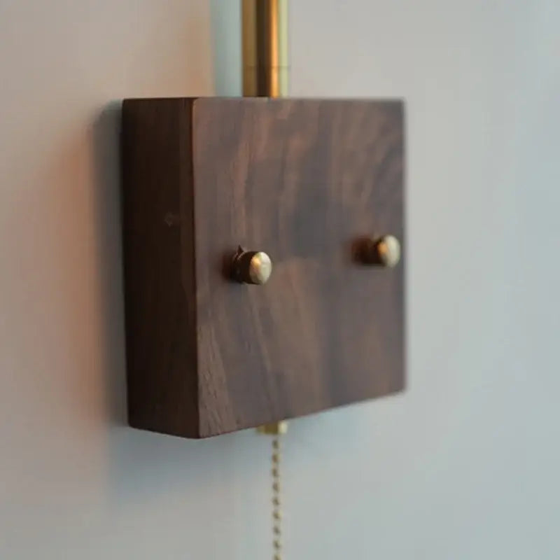 Dark walnut wood wall-mounted led wall lights with brass knobs and matching brass pull chain for bedroom use