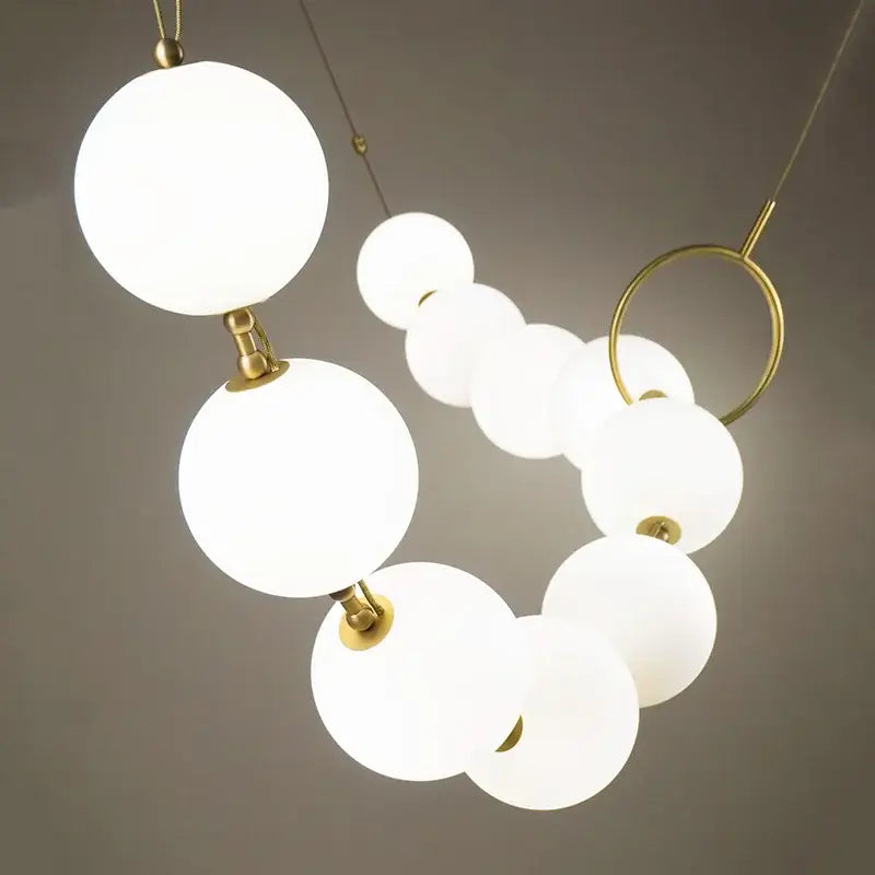 Modern brass artistic necklace chandelier pendant light with frosted white glass globes and gold-toned metal joints for living room decorbites brass artistic design