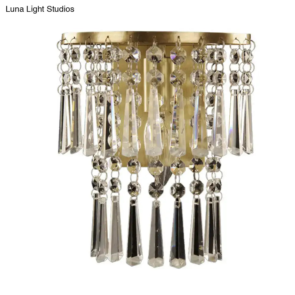 Modern brass wall sconce with gold finish featuring cascading beveled glass crystal beads and teardrop prisms
