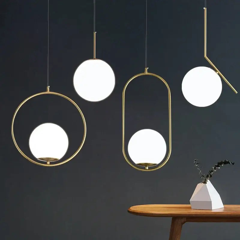 Modern brass and black glass ball pendant light with gold-toned geometric frames and glowing white glass ball shades for dining room decorbites glass ball pendant