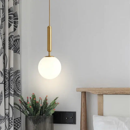 Modern brass and black glass ball pendant light with gold-toned fixture and frosted glass globe for dining room decorbites glass ball pendant