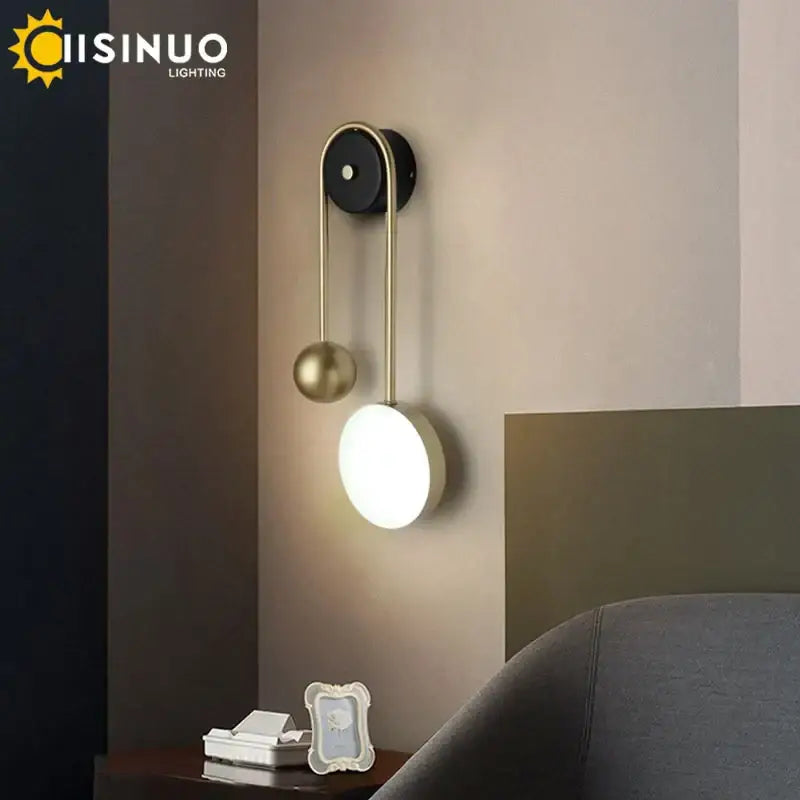 Modern brass and black led wall sconce with sleek curved arm, spherical accent, and black circular base for living room decorbites led wall