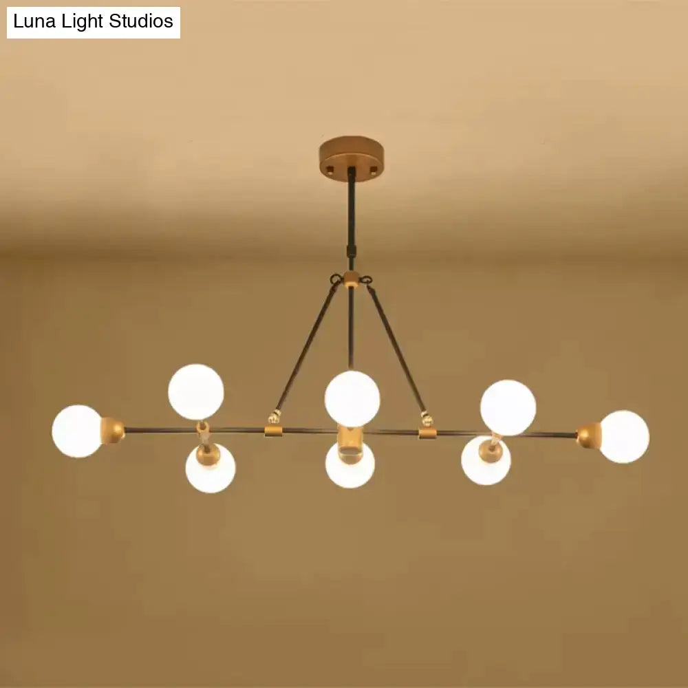Modern brass finish island light with orb shade and six frosted glass bulbs for dining room lighting