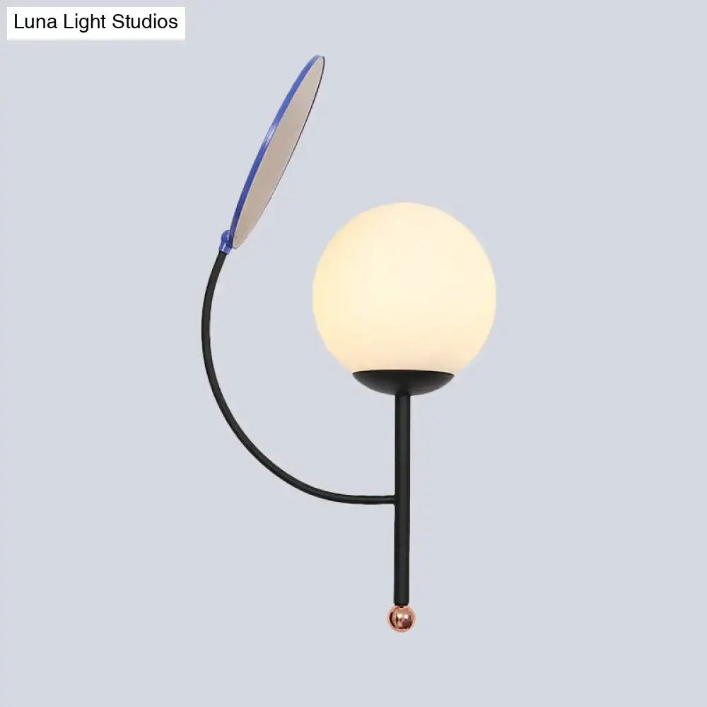 Modern black metal wall sconce with an adjustable blue-edged arm and white frosted glass spherical shade for bedroom use