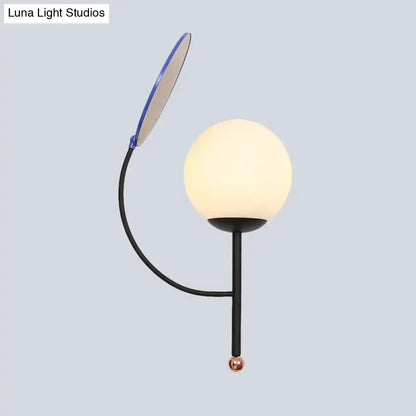 Modern black metal wall sconce with an adjustable blue-edged arm and white frosted glass spherical shade for bedroom use