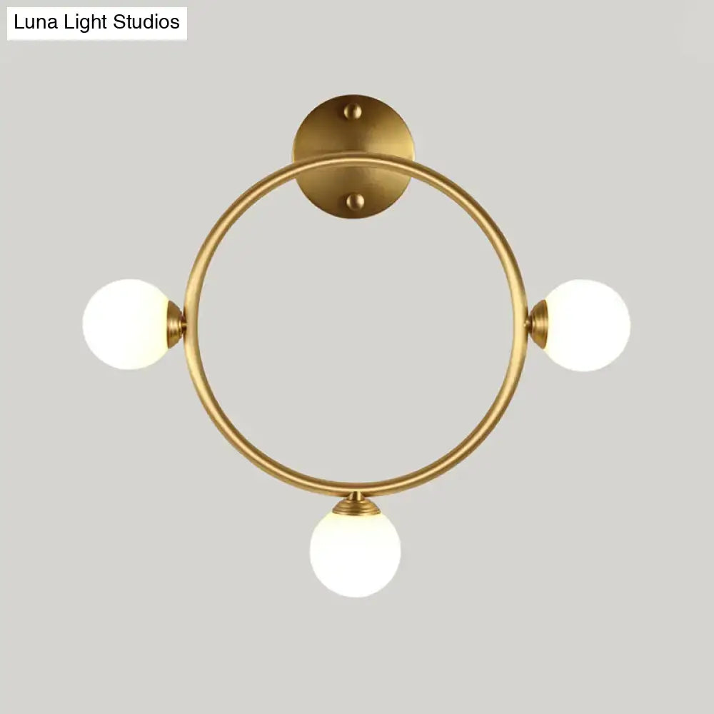 Modern brass circular wall light fixture with three frosted glass globe shades ideal for bedroom wall light fixture