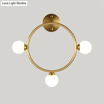 Modern brass circular wall light fixture with three frosted glass globe shades ideal for bedroom wall light fixture