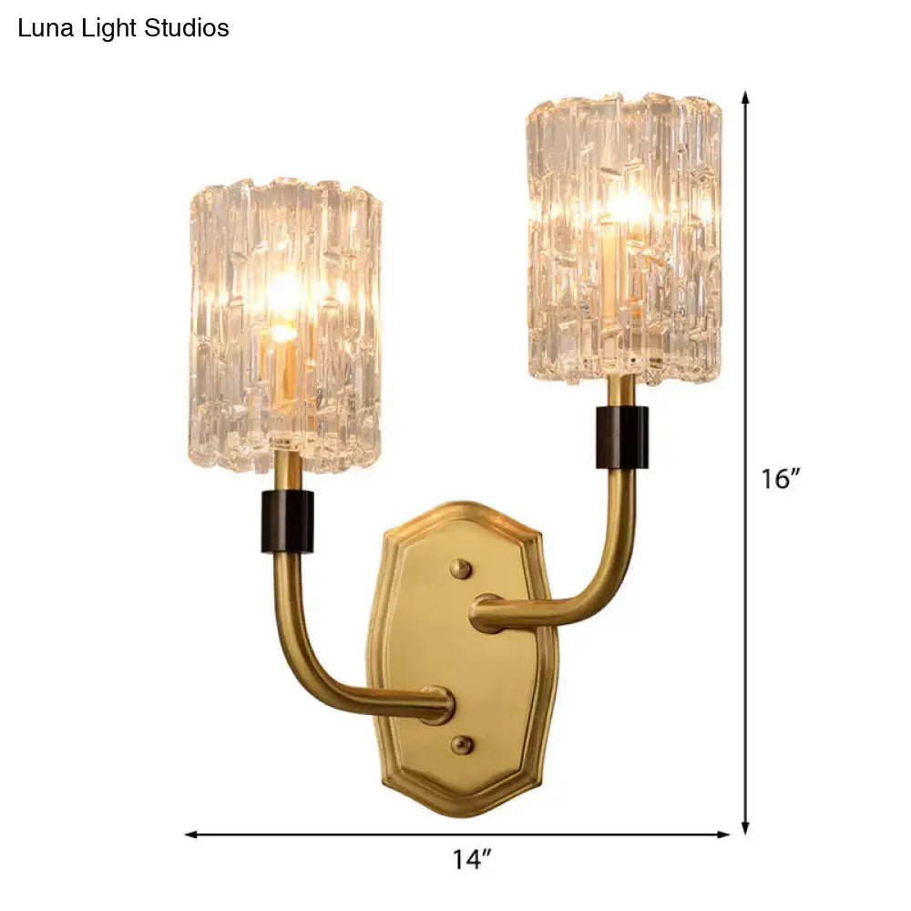 Modern brass clear glass sconce with gold-toned finish, crystal textured shades, and black accents for living room use