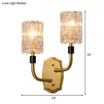 Modern brass clear glass sconce with gold-toned finish, crystal textured shades, and black accents for living room use