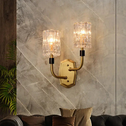 Modern brass clear glass living room wall sconce with gold-toned inch fixture and crystal encased lights with black accents