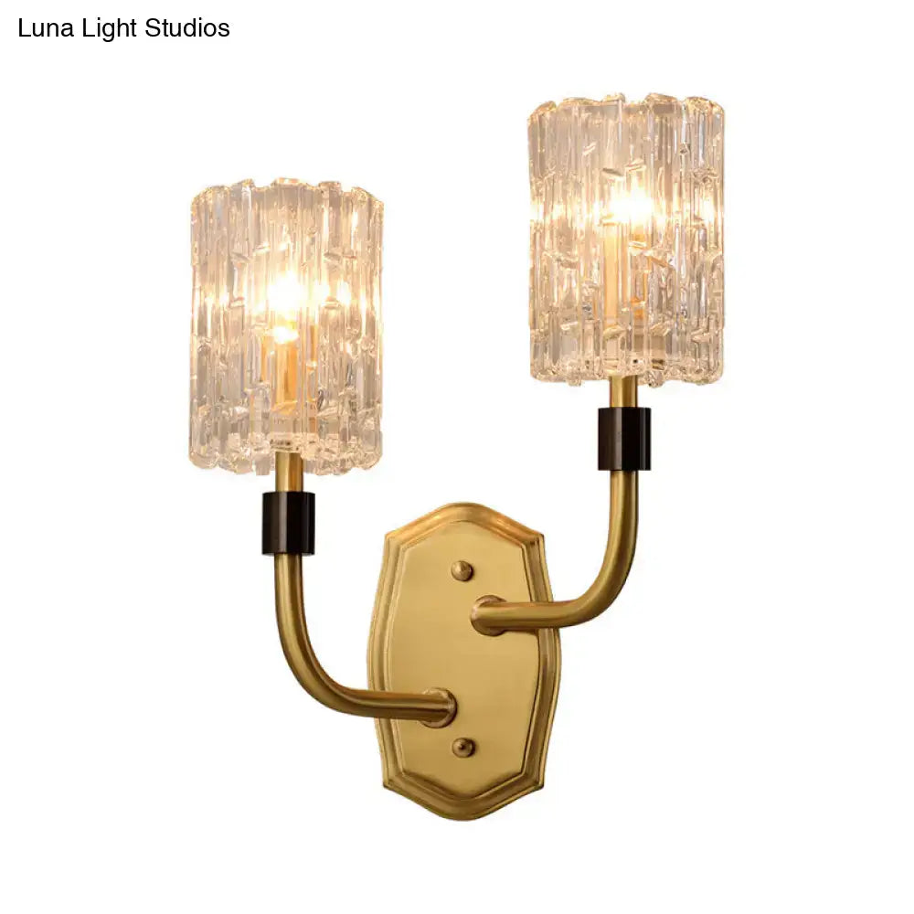 Modern brass clear glass sconce with gold-toned finish, black accents, and two textured shades for living room use
