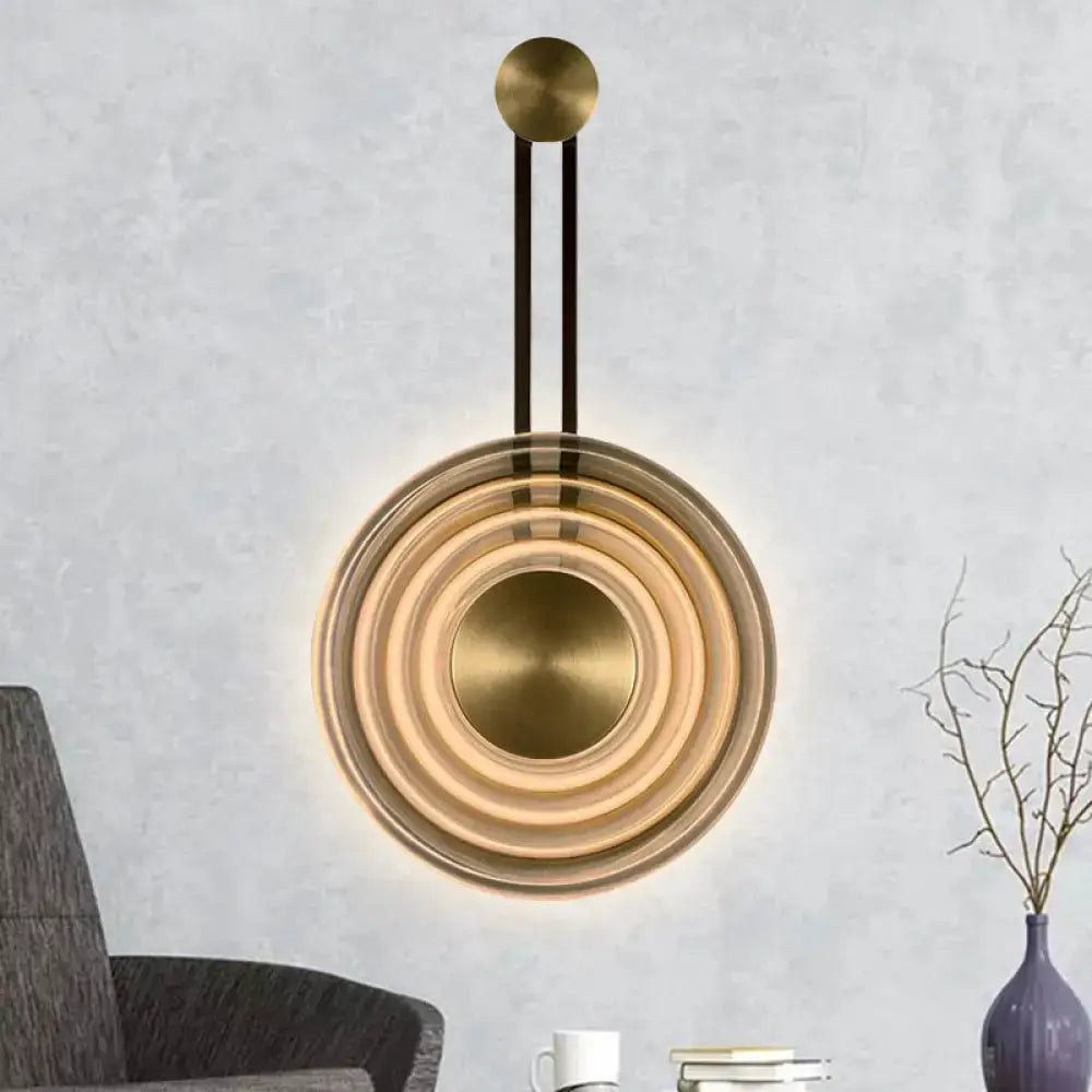 Modern brass concentric circle wall lamp with sleek minimalist design and adjustable fixture height for living room use