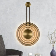 Modern brass concentric circle wall lamp with sleek minimalist design and adjustable fixture height for living room use