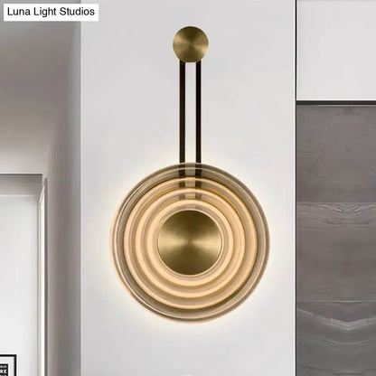 Modern brass wall lamp with concentric circular rings and sleek minimalist design highlighting fixture height for living room