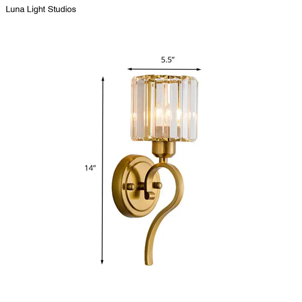 Modern brass crystal cylinder wall sconce with gold finish and curved arm featuring a crystal block cylinder shade