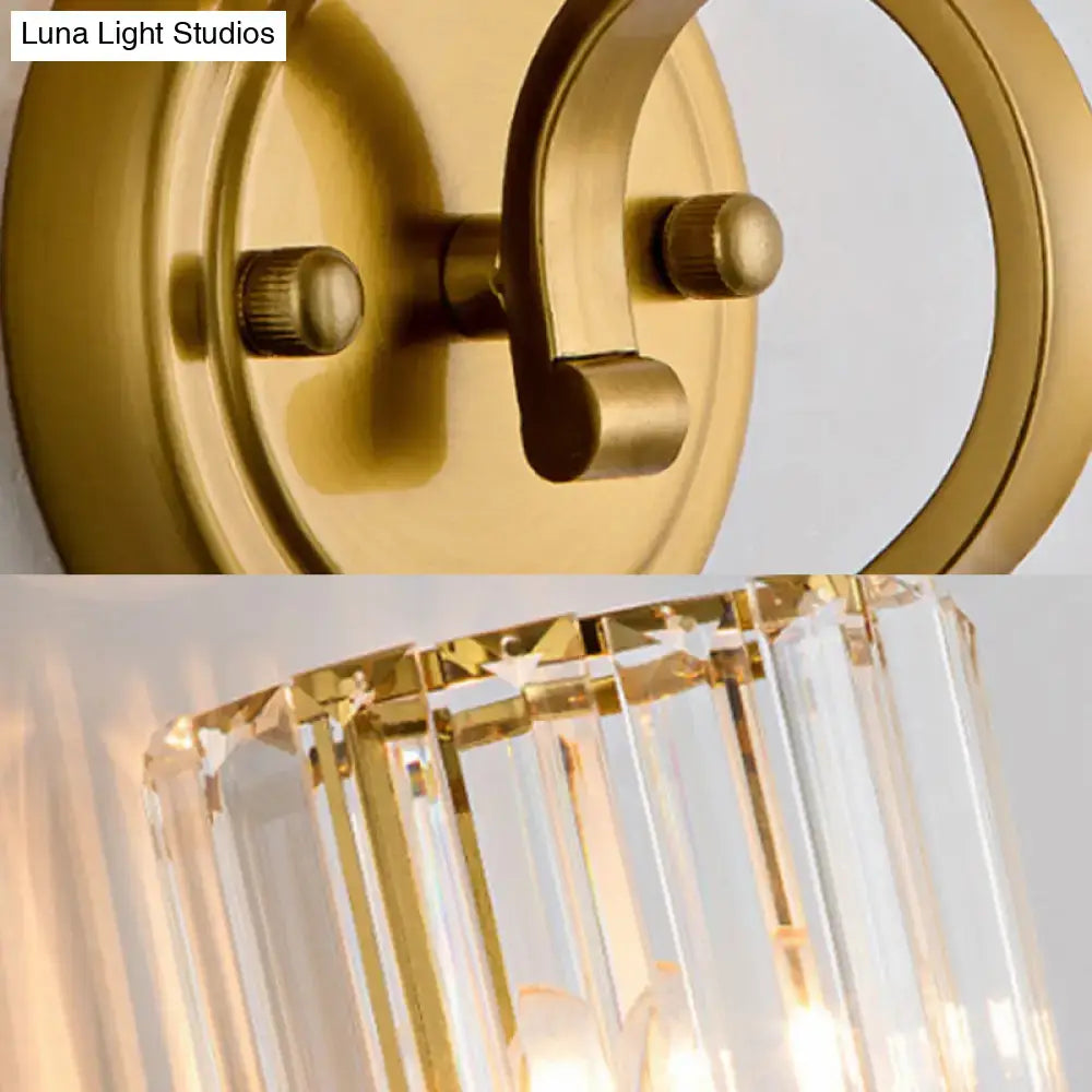 Modern brass crystal block cylinder wall sconce with gold finish circular backplate and hanging crystal prisms for bedroom light