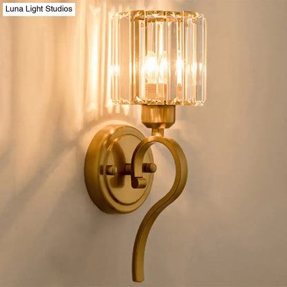 Modern brass crystal block cylinder wall sconce with gold-toned metal arm for bedroom lighting
