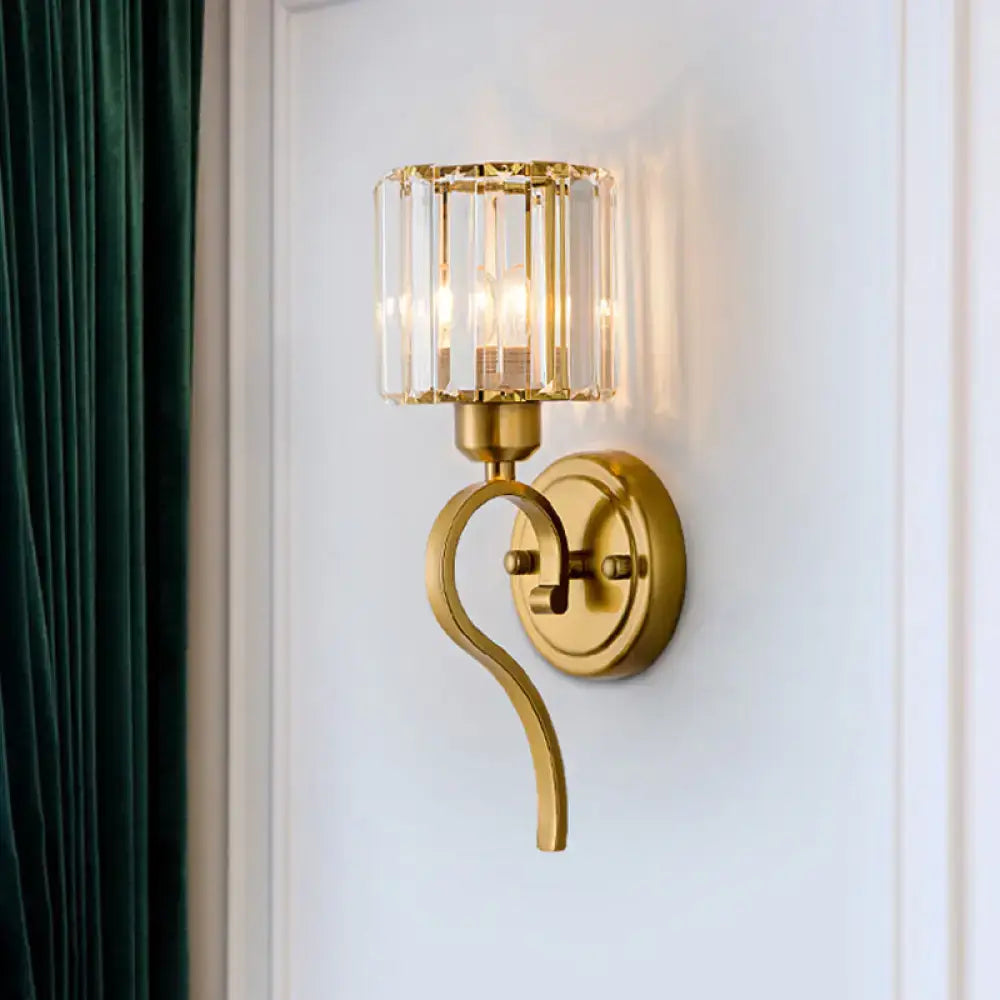 Modern brass crystal cylinder wall sconce with gold-toned curved arm and cylindrical crystal block cylinder shade for bedroom light