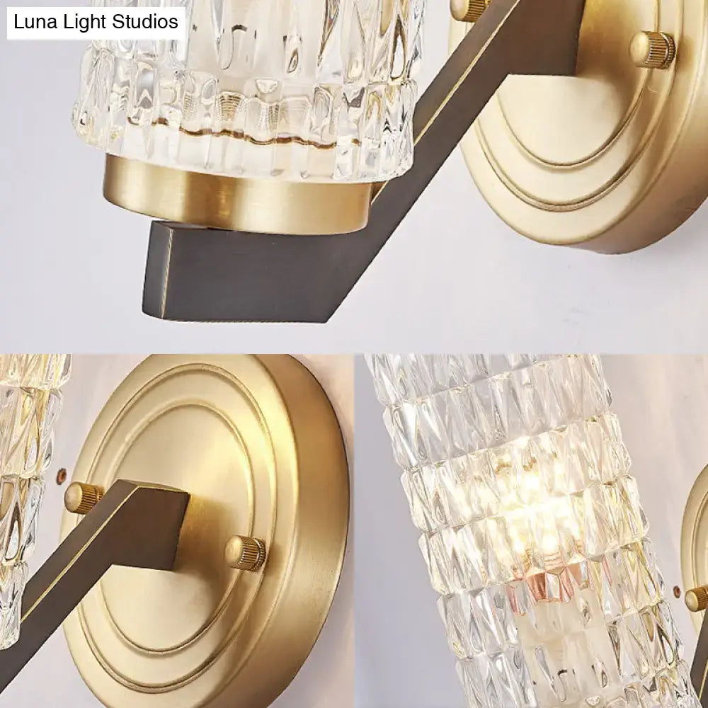Modern design flush wall sconce with clear faceted crystal glass shade and brushed brass wall lamp arm in antique bronze