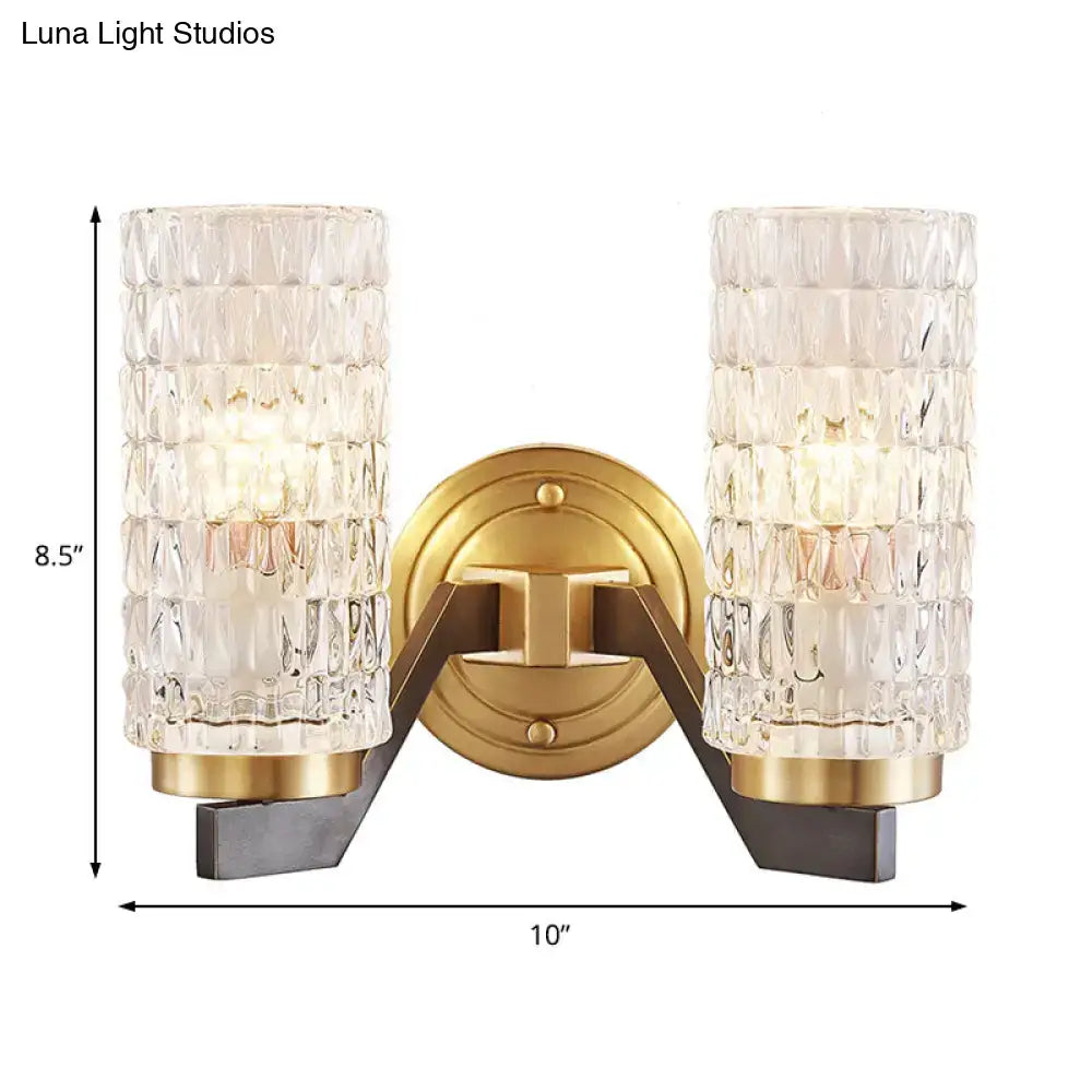 Modern brass crystal flush wall sconce with gold finish, clear textured glass cylinders, and dark metal arms wall lamp