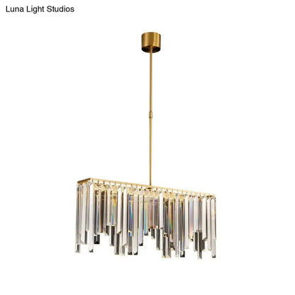 Modern brass crystal led island light with gold-toned rectangular frame and cascading clear crystal prisms for dining room