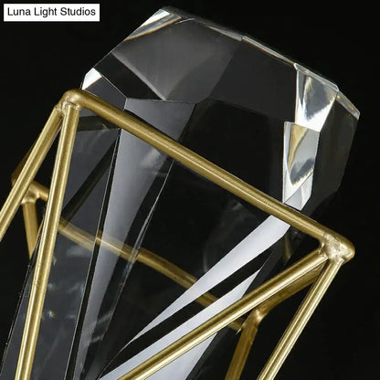 A clear crystal rock diamond-shaped planter with a gold-toned metal frame and modern brass fixture width design