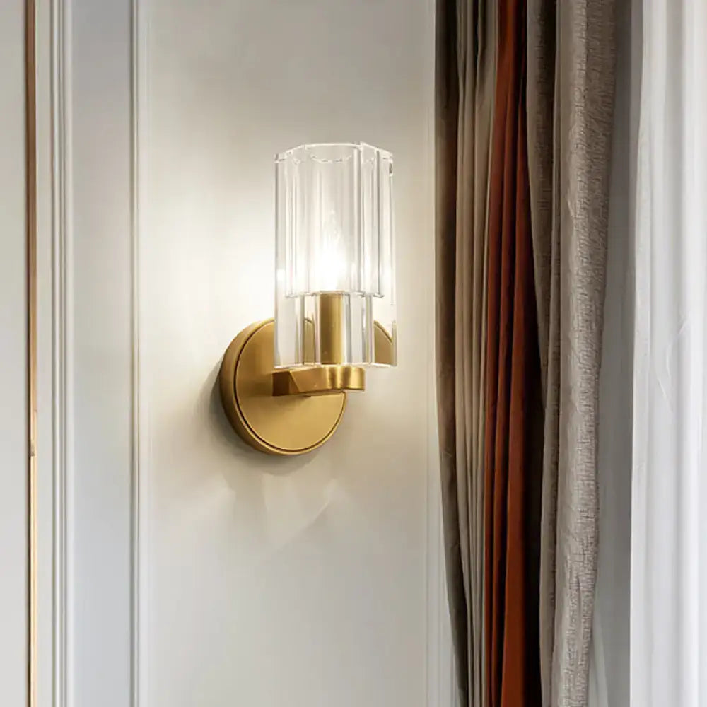 Modern brass crystal wall mount lamp with gold-toned wall mount and clear faceted glass shade for bedroom use
