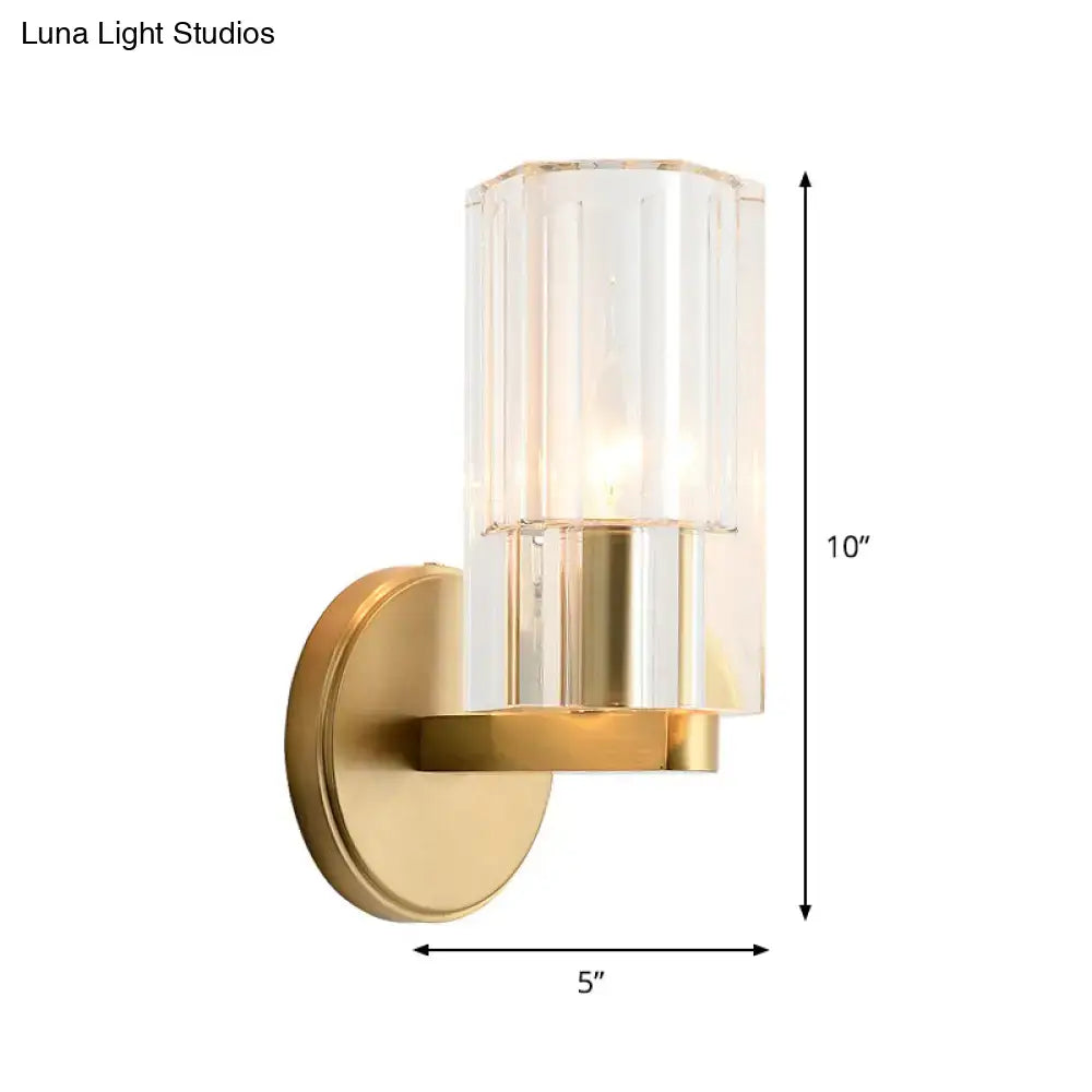 Modern brass crystal wall mount lamp with gold-toned finish and clear vertically ribbed glass shade for bedroom use
