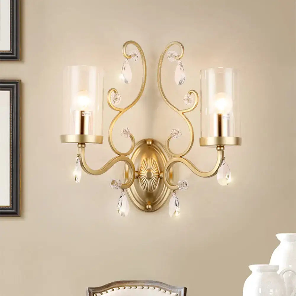 Modern brass crystal wall mounted light featuring a gold-toned ornate dual glass shade mounted light with crystal droplets