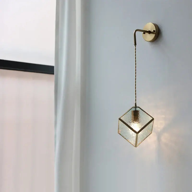 A modern brass-finished led wall sconce with a textured glass cube and pull switch for decorbites led wall lights