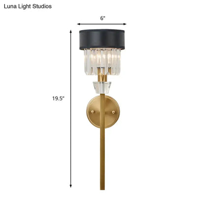 Modern brass cylinder wall sconce with gold metal base and black fabric shade featuring clear crystal prisms for bedroom light