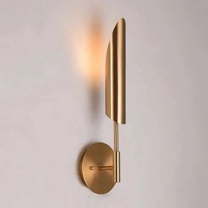 Modern brass cylindrical wall light with gold-toned leaf-shaped shade showcasing decorbites golden luxury wall design