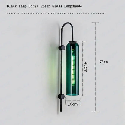 A sleek black metal modern brass e27 glass wall light with a tall green glass shade and illuminated led filament bulb
