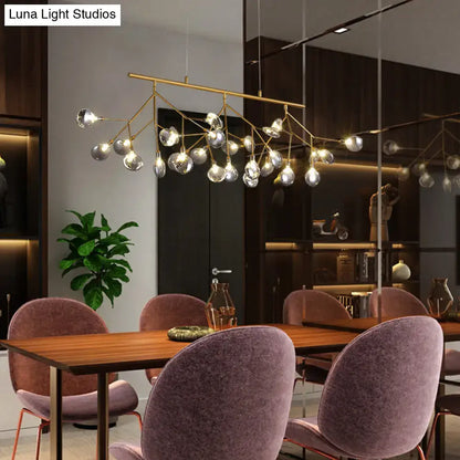 Gold-toned decorbites™ island light with brass finish and clear glass globes compatible with 220v-240v 110v-120v