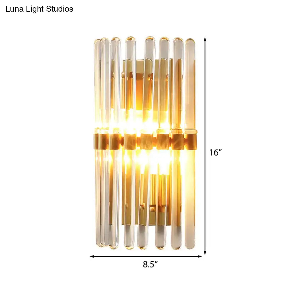 Modern sconce lamp with brass finish featuring clear crystal and amber glass tubes in a sleek vertical bedroom design